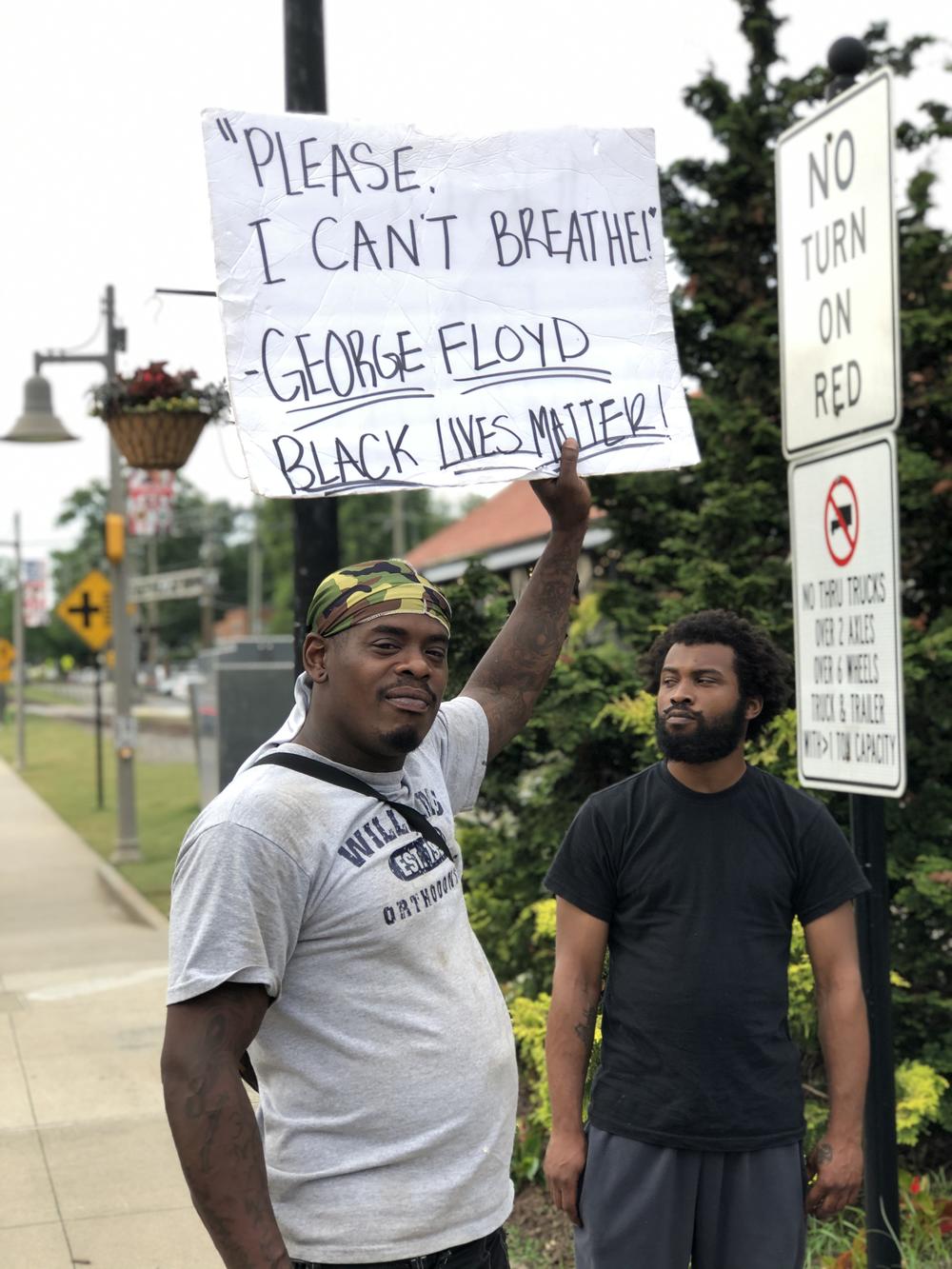 A man in downtown Woodstock holds a sign echoing some of the last words George Floyd and, in 2014, Eric Garner cried out before dying in police custody.