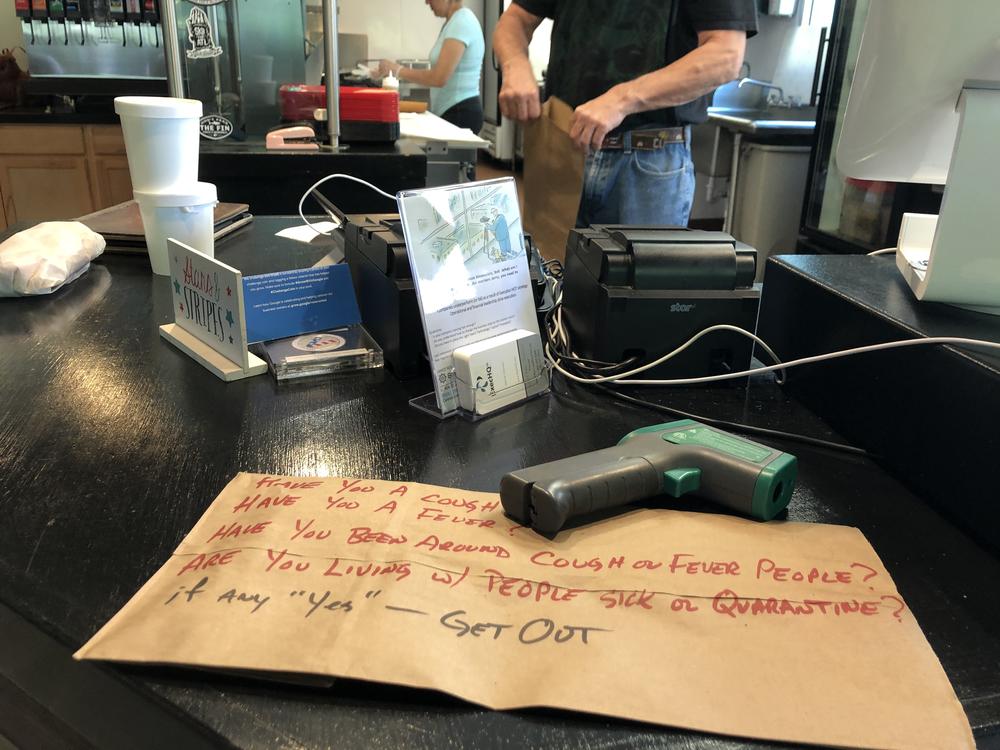 A no-touch thermometer device sits at the ready for customers picking up orders at the Crazy Cuban restaurant near midtown Atlanta.