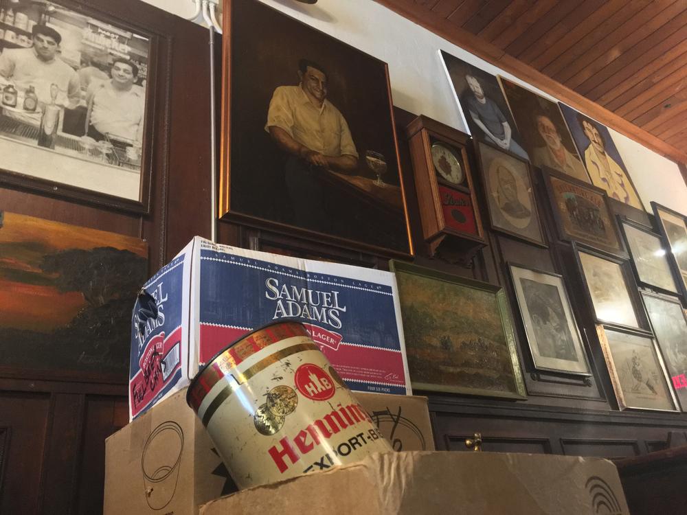A portrait of Manuel Maloof sits above a box of beer cans that have yet to be hung on the wall.