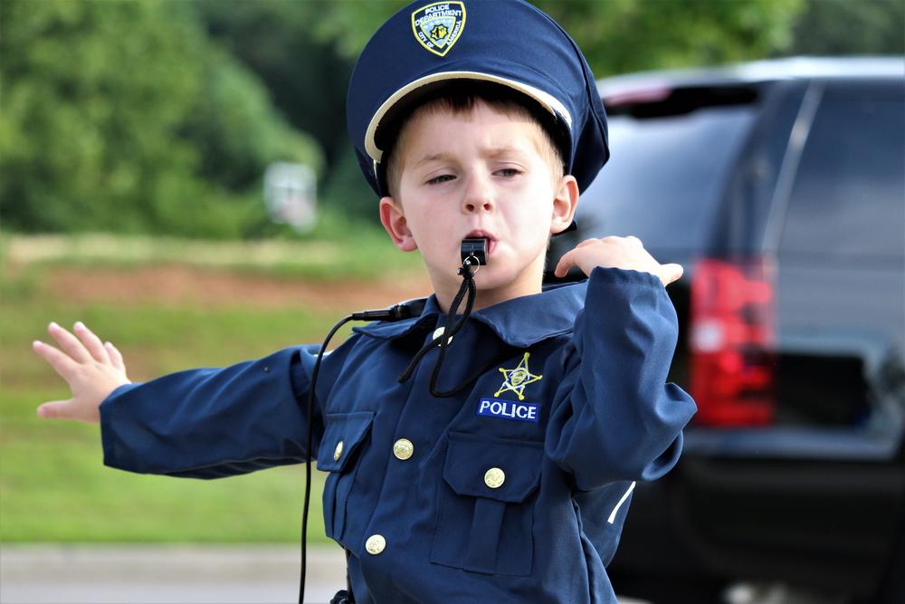 An eager future police officer pretends to direct traffic as people gather for the Canton police lip sync challenge video shoot Thursday July 26 in Etowah River Park.