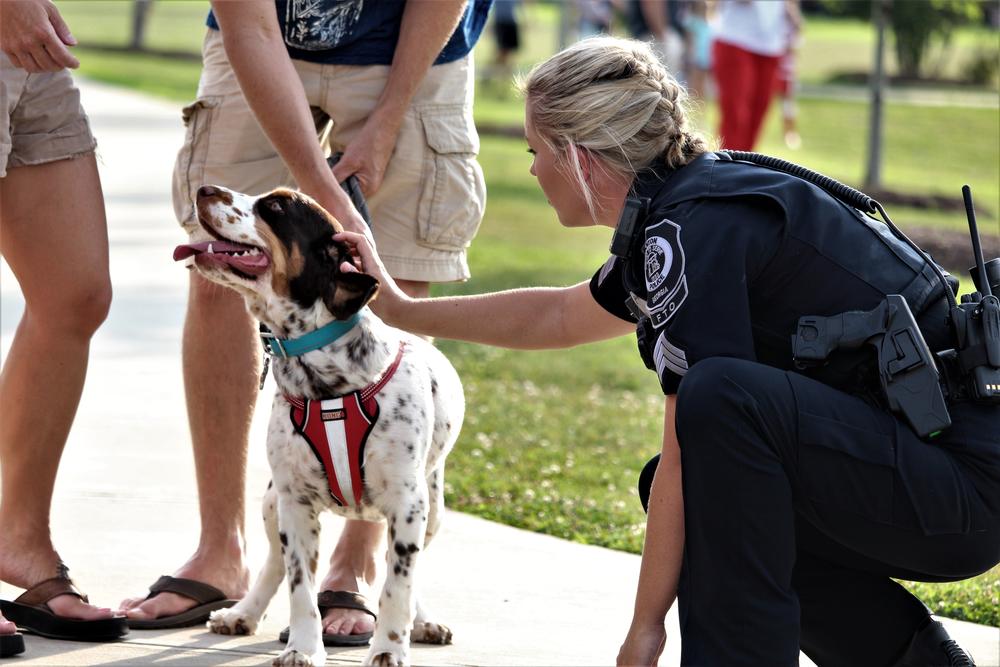 A Canton field training officer takes a few minutes to say hello to concert atttendees during the police lip sync challenge video shoot Thursday July 26 in Etowah River Park.