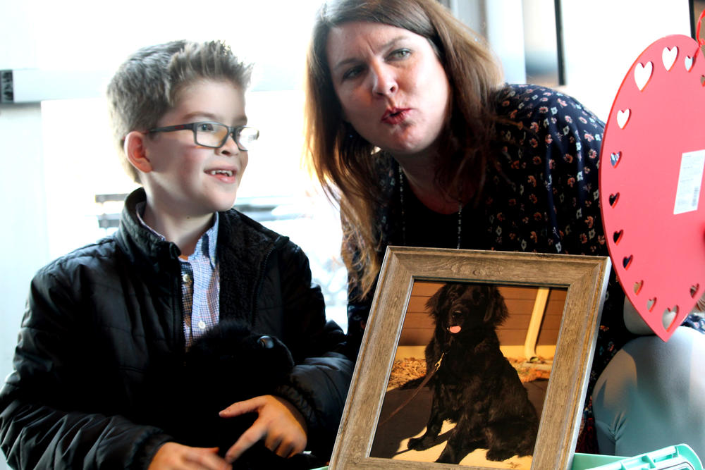 Brody sees a photo of his service dog, Chipotle, with his mother, Meghan Roberts. The celebration took place at a Kennesaw Chipotle restaurant. 