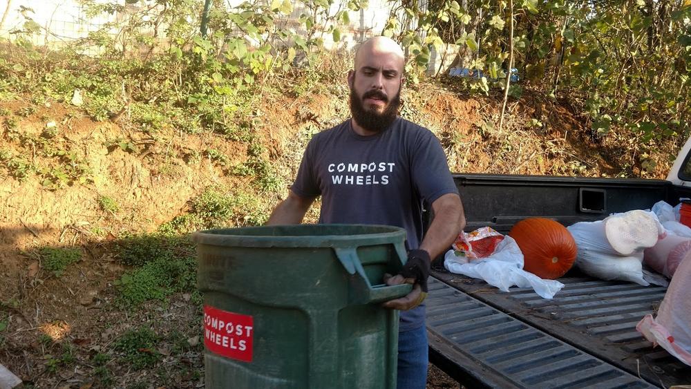 Whit Whitmire of Compostwheels carries a bucket full of food waste that he's collected during the day. He'll put this in a compost pile at Freewheel Farm in Atlanta.