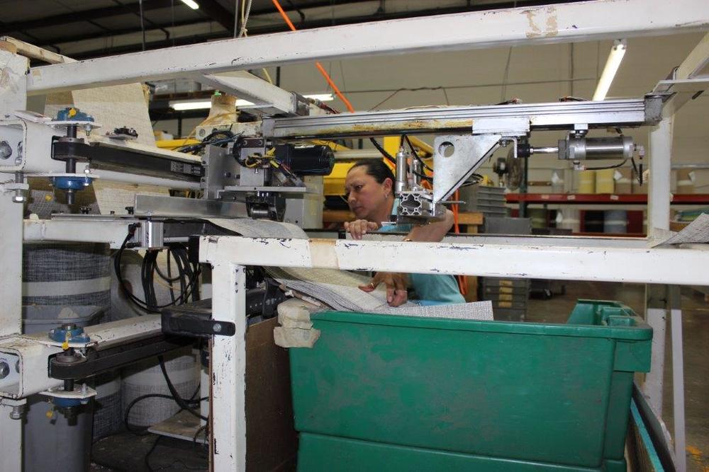 A worker guides the creation of high-end vinyl table, floor and wall coverings at the Chilewich textile factory in Murray County, Georgia. 