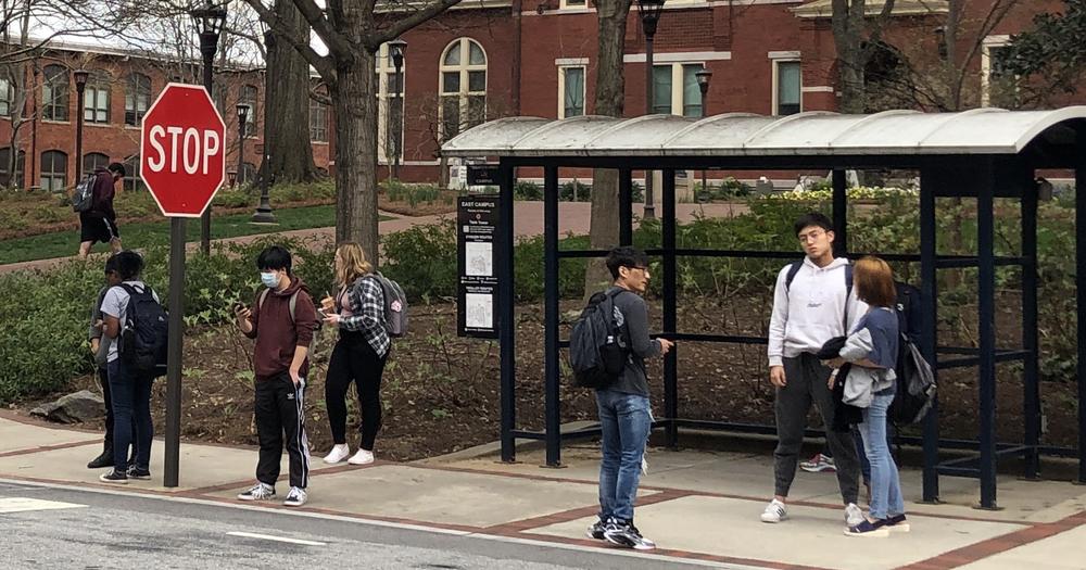 Students wait for a bus as concerns about Coronavirus grow.