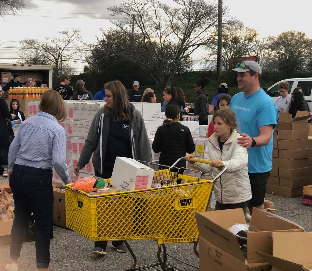 Volunteers load carts with food to distribute to families in need.