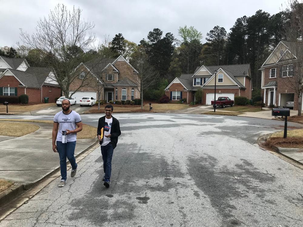 Daniel Hilton and Krupesh Patel knock on doors in a Snellville neighborhood, trying to rally enthusiasm for primary voting in Gwinnett County. 