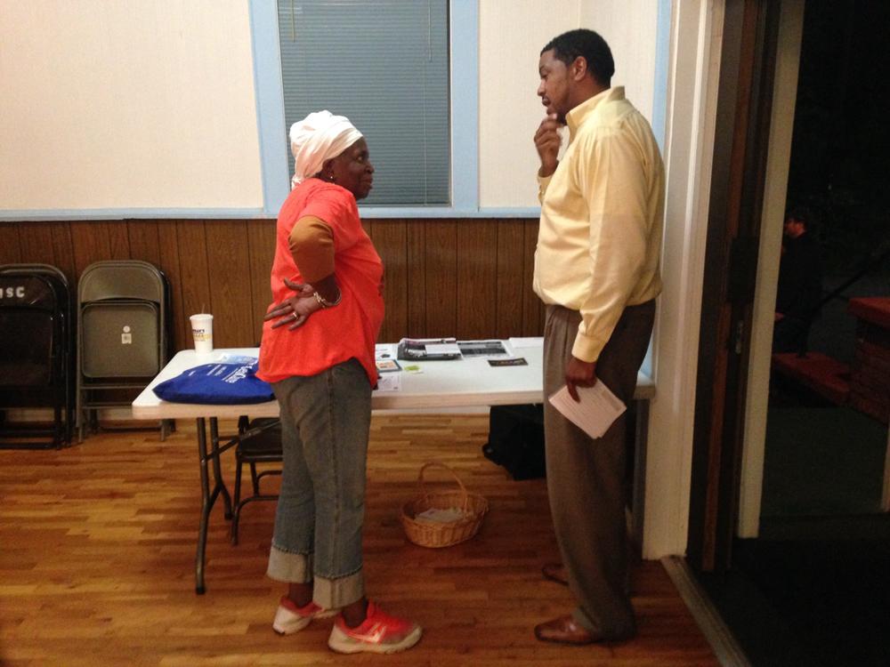 Yasin Efundele asking a community member whether he's taken the survey.