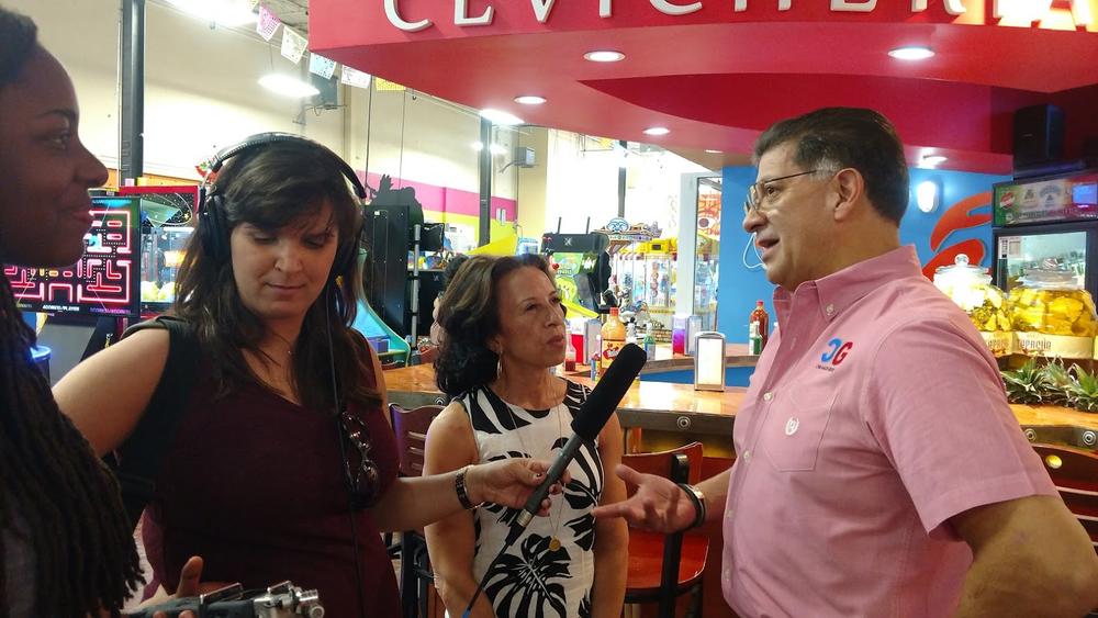 (l to r): Latino USA producers Zakiya Gibbons and Jeanne Montalvo Lucar listen as host  Maria Hinojosa interviews Carlos Chavez, a restaurant owner at Plaza Fiesta in Chamblee, Georgia.