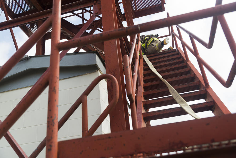 One of the Dodge State Prison firefighters scrambles up a disused guard tower they now use for training during a training demonstration recently. 