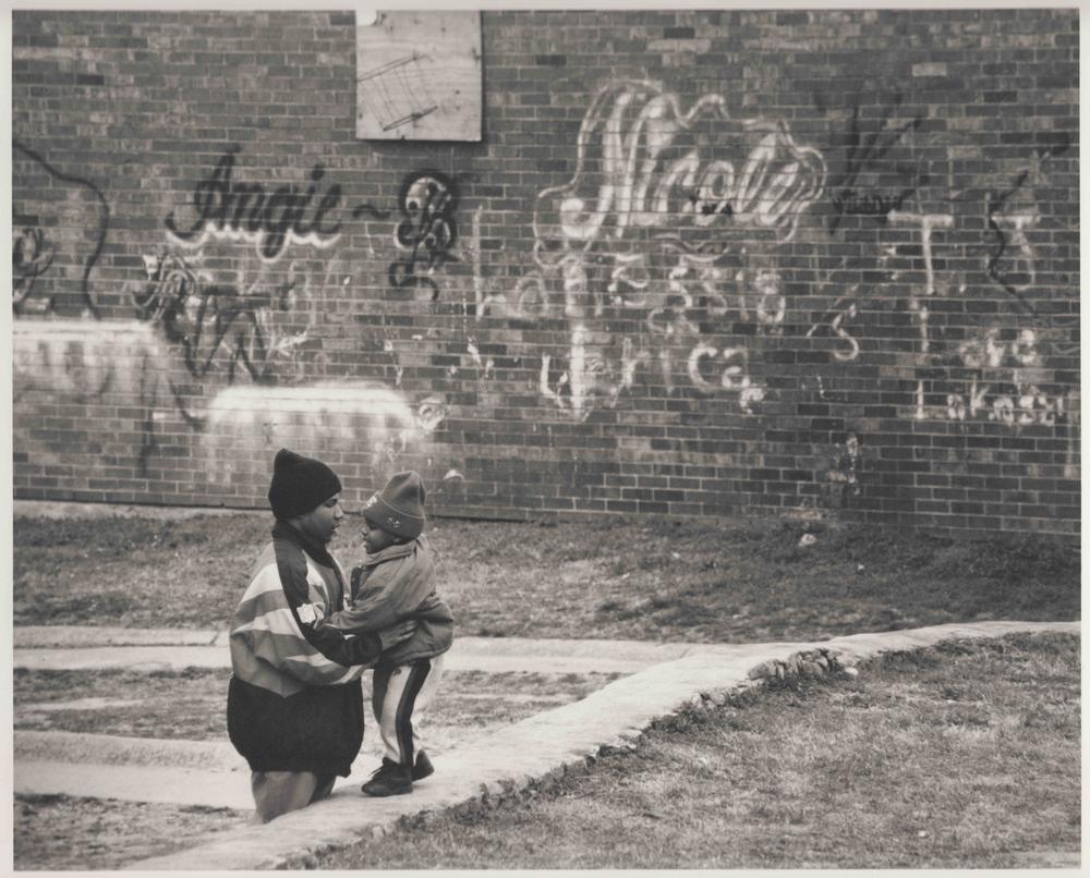 A man and child next to a wall full of graffiti in the East Lake area of Atlanta, 1996. The documentary "East Lake Meadows: A Public Housing Story" airs on PBS on Tuesday, Mar. 24 at 8 p.m.