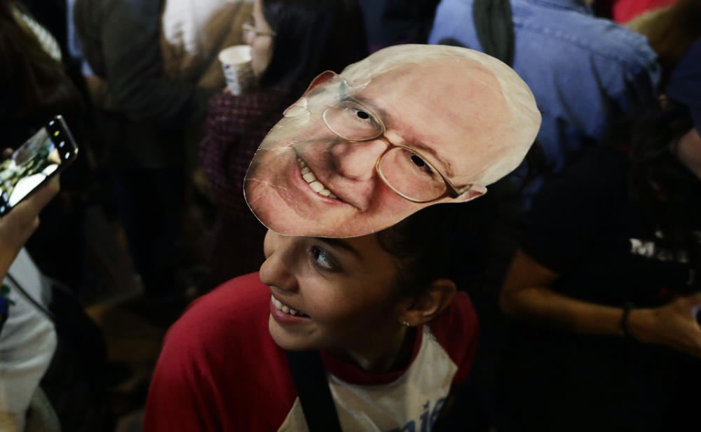 Michelle Nicoleq wears a Bernie Sanders mask as she attends a campaign event for Democratic presidential candidate Sen. Bernie Sanders, I-Vt., in San Antonio, Saturday, Feb. 22, 2020.