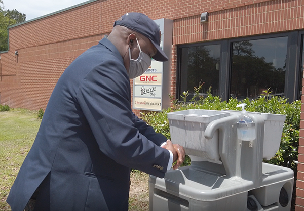 Savannah Mayor Van Johnson sports a mask and washes his hands during a May visit to Hunter Army Airfield. 