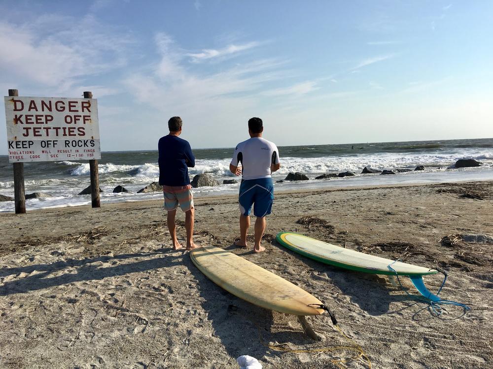 Surfers contemplating waves at Tybee Island.