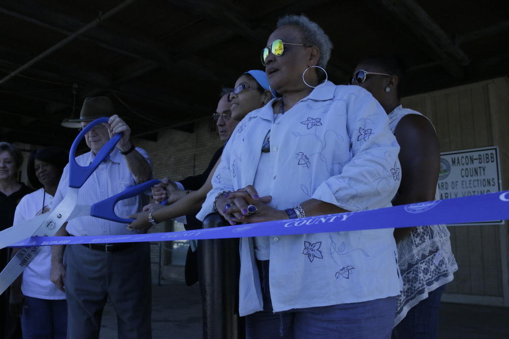 Macon-Bibb Board of Elections Chair Cassandra Powell (in foreground) with local leaders and other elections officials cutting the ribbon to open a new early voting election space at the city's bus terminal. 