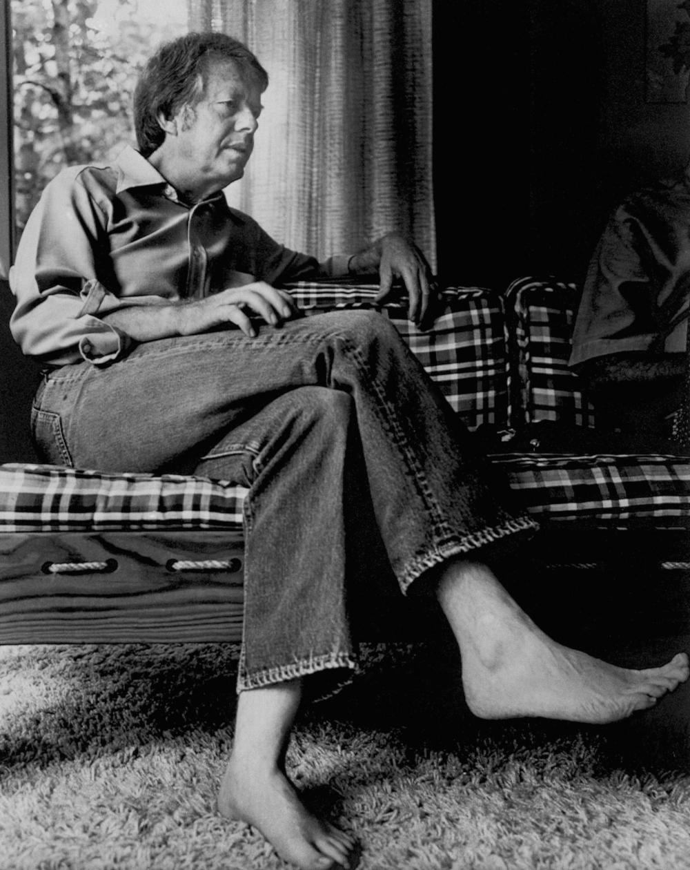 Former Georgia Governor Jimmy Carter, wearing jeans and barefooted, talks with newsmen in his home in Plains, Ga., Aug. 1975. 
