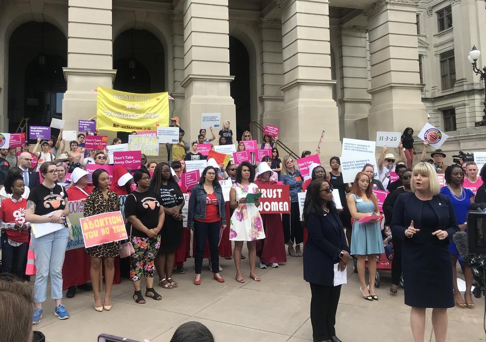 Dozens of people gathered on the steps of the Capitol after Gov. Kemp signed HB 481, which bans abortion after six weeks. The ACLU and Planned Parenthood each vowed to fight the measure in court.