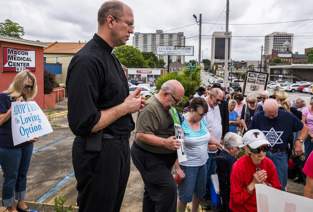Father Scott Winchel of Macon's St. Joseph's Catholic Church leads protesters in prayer outside the proposed location of the Summit Medical Center in Macon. The clinic would be the first abortion provider in Macon in decades.