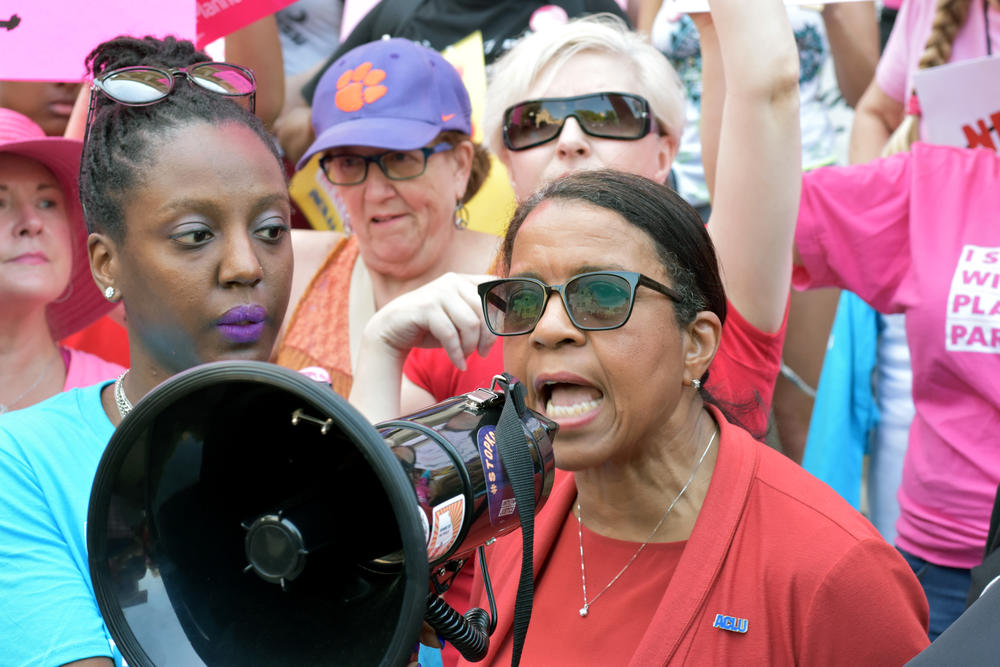 ACLU of Georgia Executive Director Andrea Young speaks into a megaphone at a rally outside of the state capitol building May 21, 2019. 
