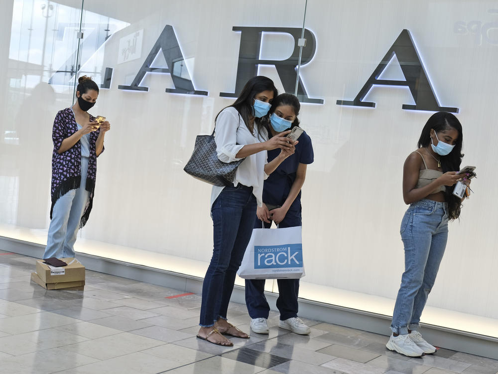 Customers wait in line to enter a Zara store inside the newly reopened Garden State Plaza mall in Paramus, N.J., on June 29.