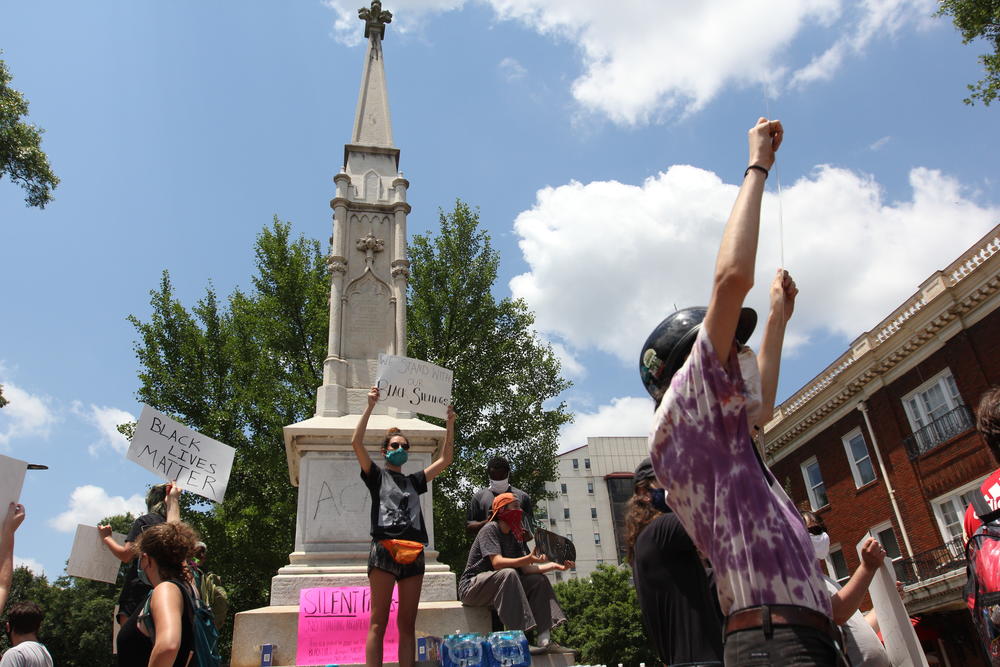 Protesters gather at a Confederate monument in Athens, which has been vandalized with anti-police slogans. The county might move the monument.