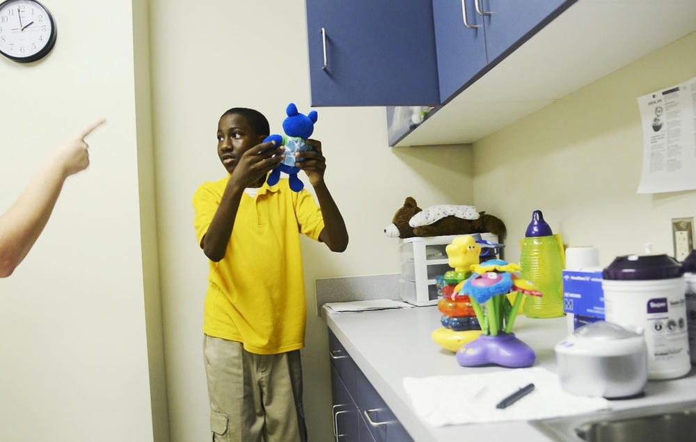 Akeeth Godfrey, center, 14, listens carefully during his therapy session at the Autism Center at Navicent Health. Before he was accepted to the new center, Akeeth and his family were dealing with his autism as best they could on their own. 