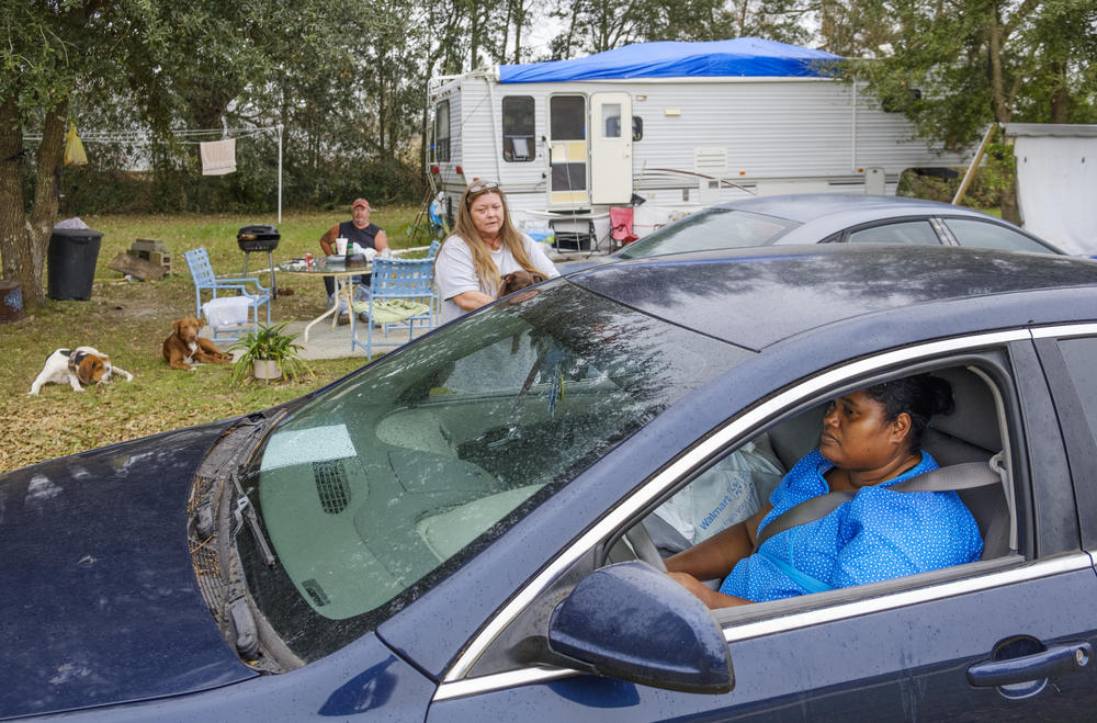 Tina Owens talks to her neighbor Sandra Thornton outside her camper in the weeks after Hurricane Michael.