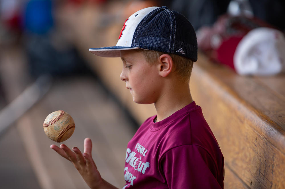 Fans of all ages including this young boy, the son of a player for the amateur team known as the Red Sox, turned out to watch his father's team play.