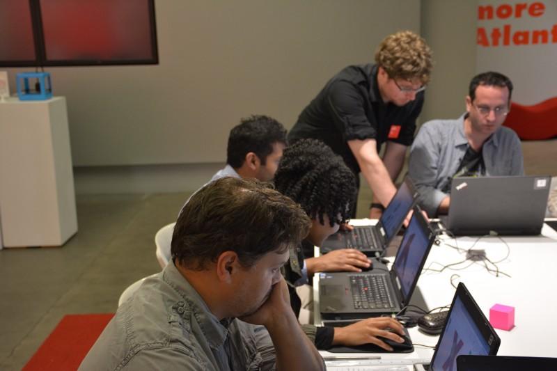 Miller assisting one student while the others focus on their designs.