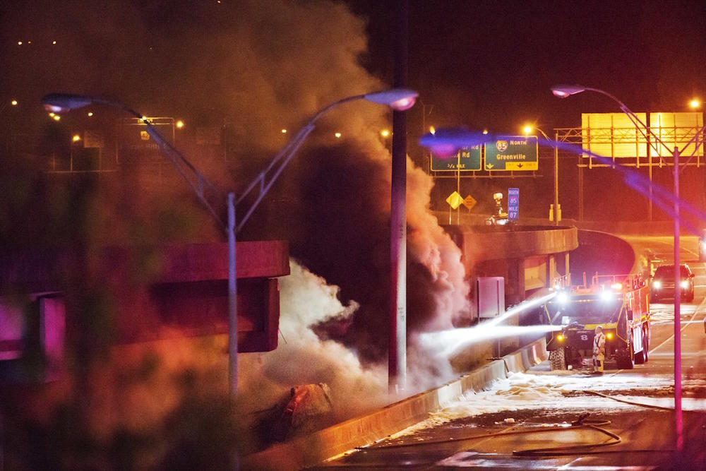 Smoke billows from a section of an overpass that collapsed from a fire on I-85 in Atlanta, Thursday, March 30. Troopers were telling cars to turn around on the bridge because they were concerned about its integrity. Minutes later, the bridge collapsed.