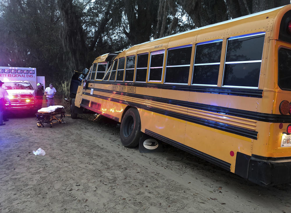 Authorities investigate the scene where a school bus crashed, Tuesday, Dec. 5, 2017, in Gum Branch, Ga. Liberty County Public Safety Director Mike Hodges said more than 20 children were riding the bus when it crashed into a tree during its morning route.