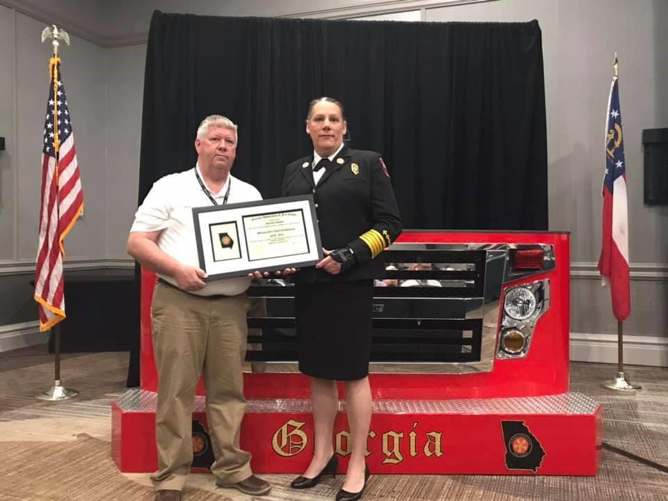 Byron Fire Chief Rachel Mosby receives the Georgia Fire Chief Certification through the Georgia Association of Fire Chiefs from Charles Wasdin at the Georgia Association of Fire Chiefs conference in April.
