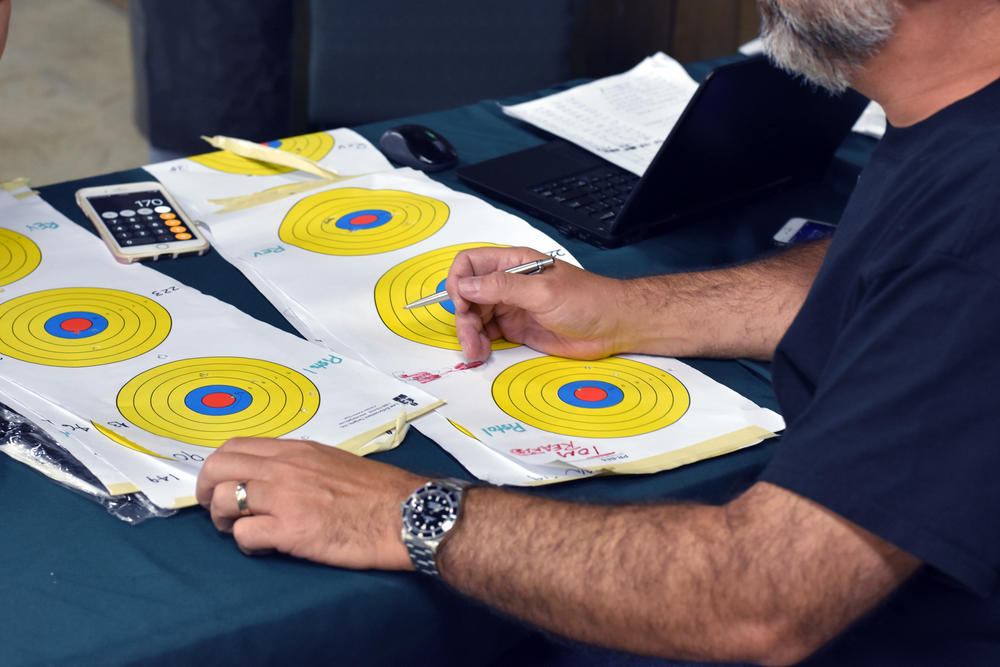 A volunteer scores the targets of several participants in the 11th District GOP's Fifth Annual Marksmanship Event and Barbecue