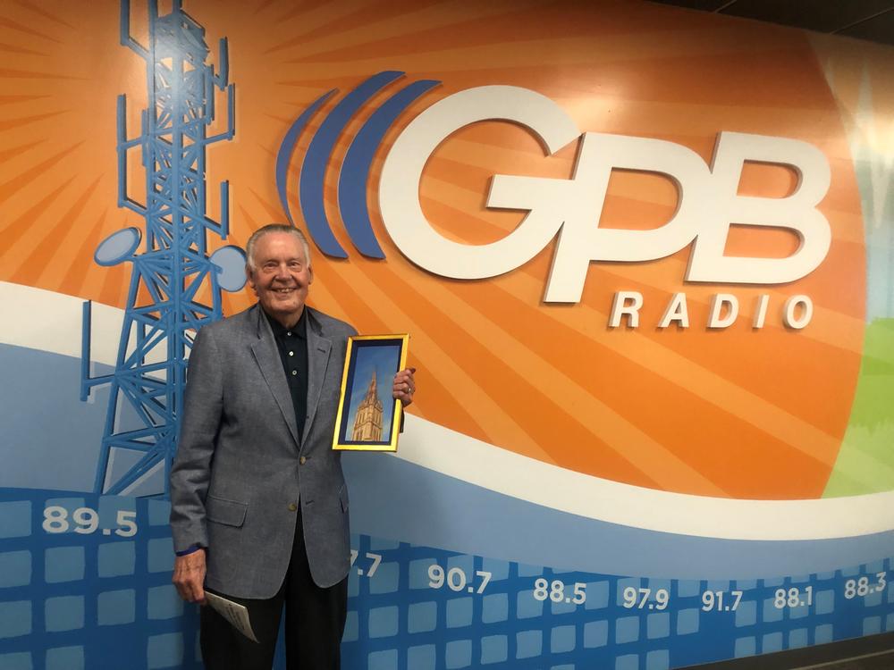 Dick Yarbrough pictured with his own original painting and recently published editorial.