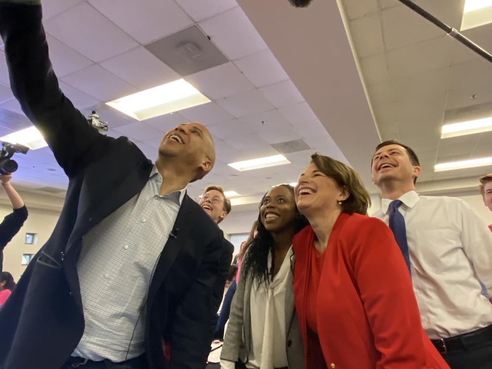Sen. Cory Booker, Fair Fight Georgia's Esosa Osa, Sen. Amy Klobuchar and Mayor Pete Buttigieg smile for a selfie at a Fair Fight text bank contacting voters facing removal from Georgia's voter rolls.