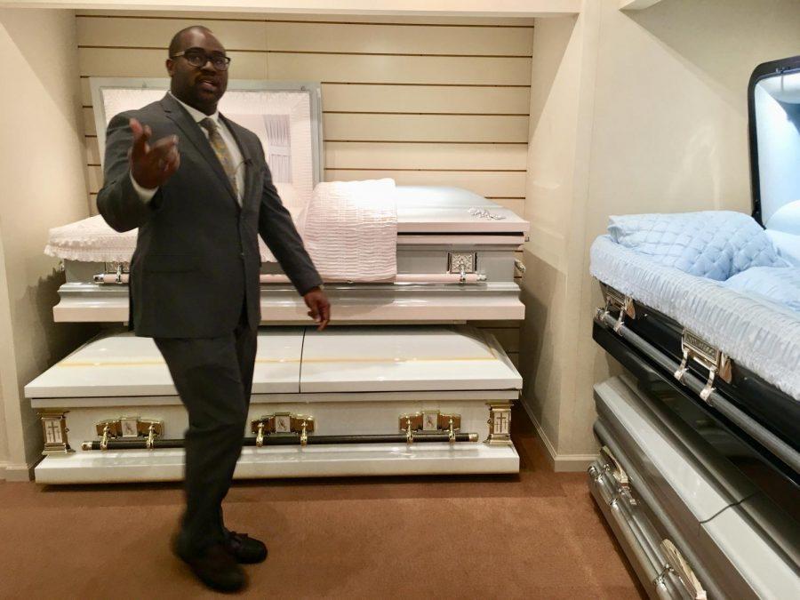 Funeral home owner Richard Robinson leads reporters through his casket showroom as an example of how he plans tours for young people in an effort to curb deadly violence in Macon.