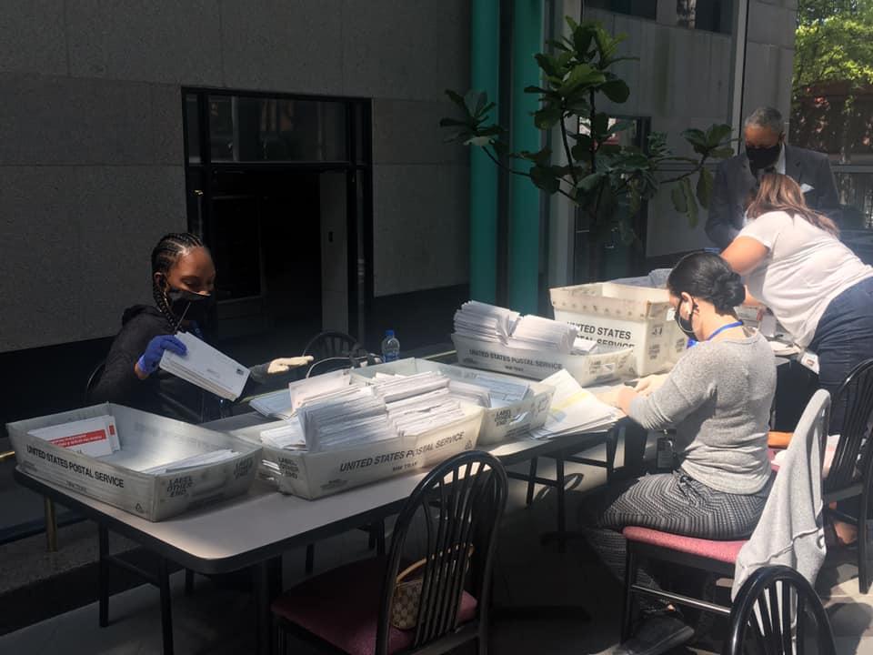 Fulton County Government employees process stacks of absentee ballot applications.