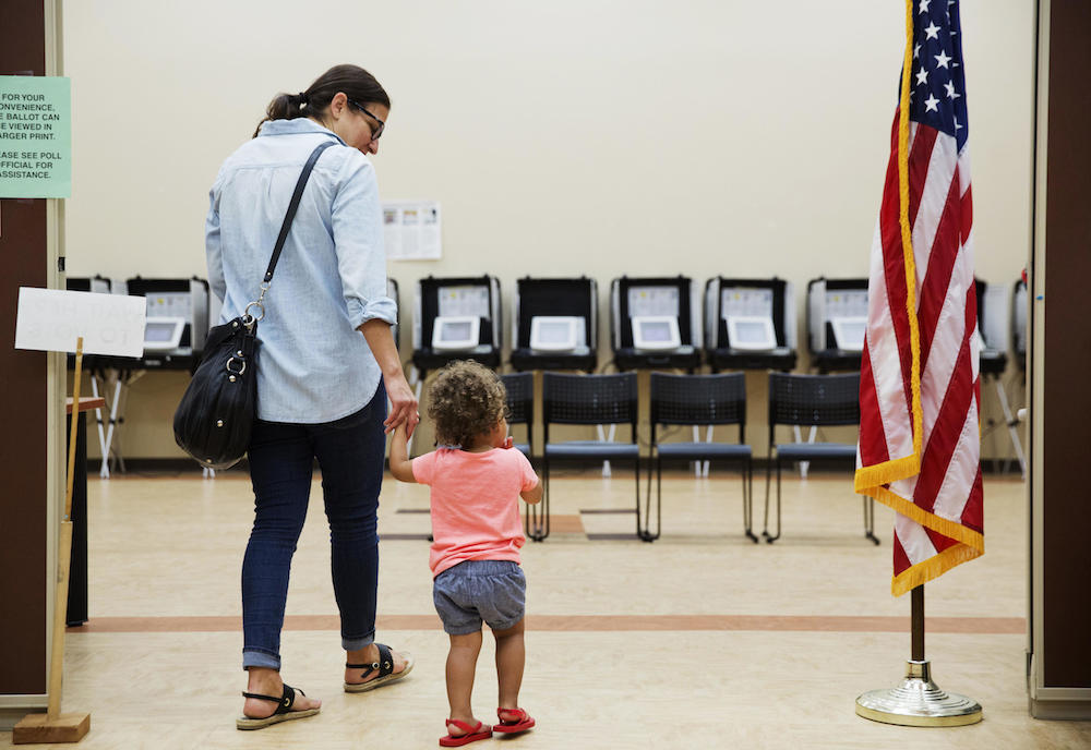 Melissa Painter walks with her one year-old daughter Elle to vote in Georgia's 6th Congressional District special election at a polling site in Sandy Springs, Ga., Tuesday, June 20, 2017.