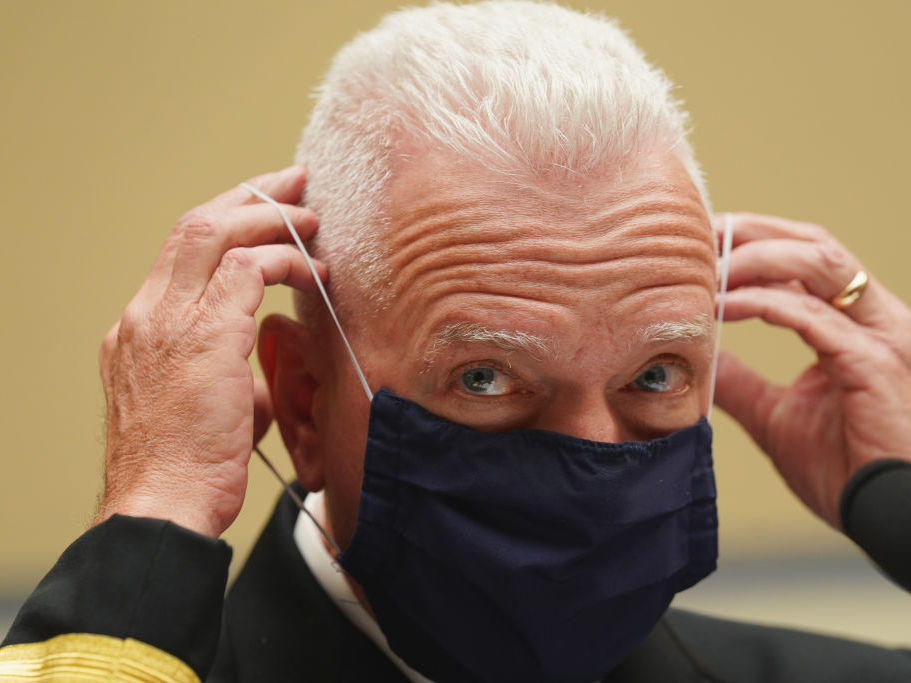 Adm. Brett Giroir, assistant secretary for health in the Department of Health and Human Services, adjusts his face mask while testifying this month before a House subcommittee on the coronavirus crisis.
