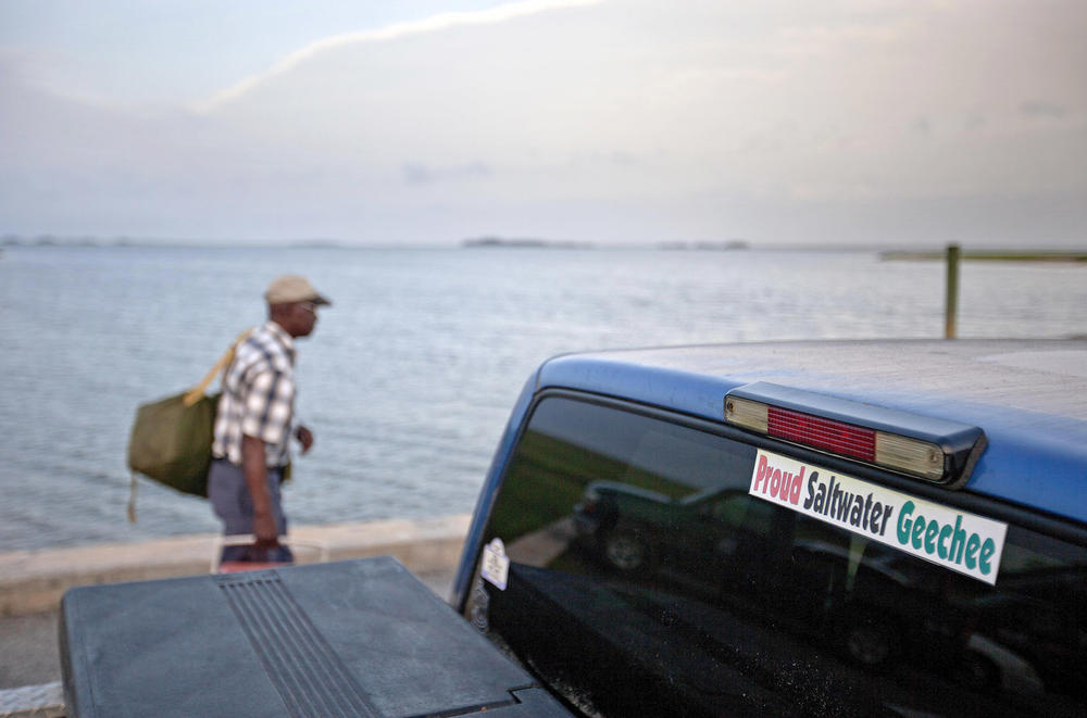 In this June 10, 2013 file photo, a sticker celebrating the Geechee heritage is seen on a pickup truck as passengers board a ferry to the mainland from Sapelo Island, Ga.