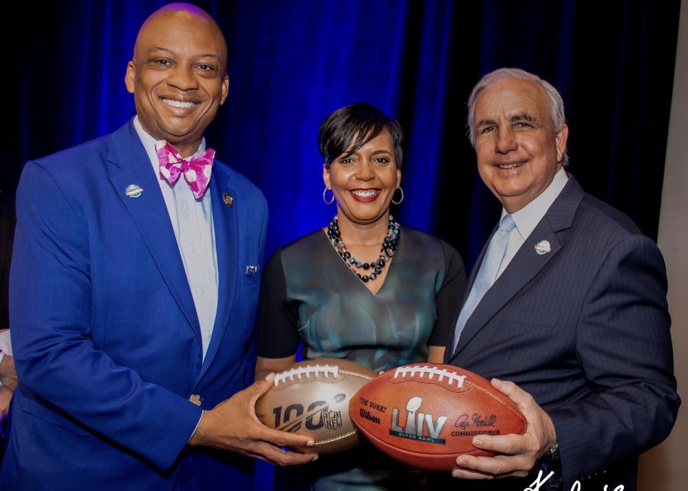 Oliver Gilbert (left) and Atlanta Mayor Keisha Lance Bottoms handoff the Super Bowl to Miami-Dade County Mayor Carlos Gimenez.