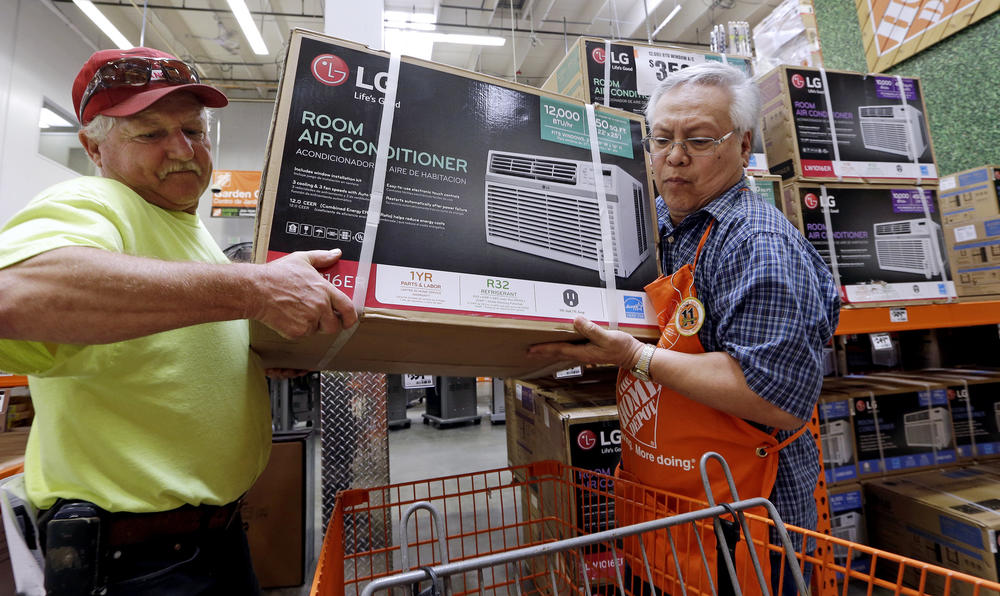 Home Depot store greeter Danny Olivar, right, helps a customer buying an air conditioner. A new study finds Georgians will need to adapt to more days of extreme heat in the coming decades.