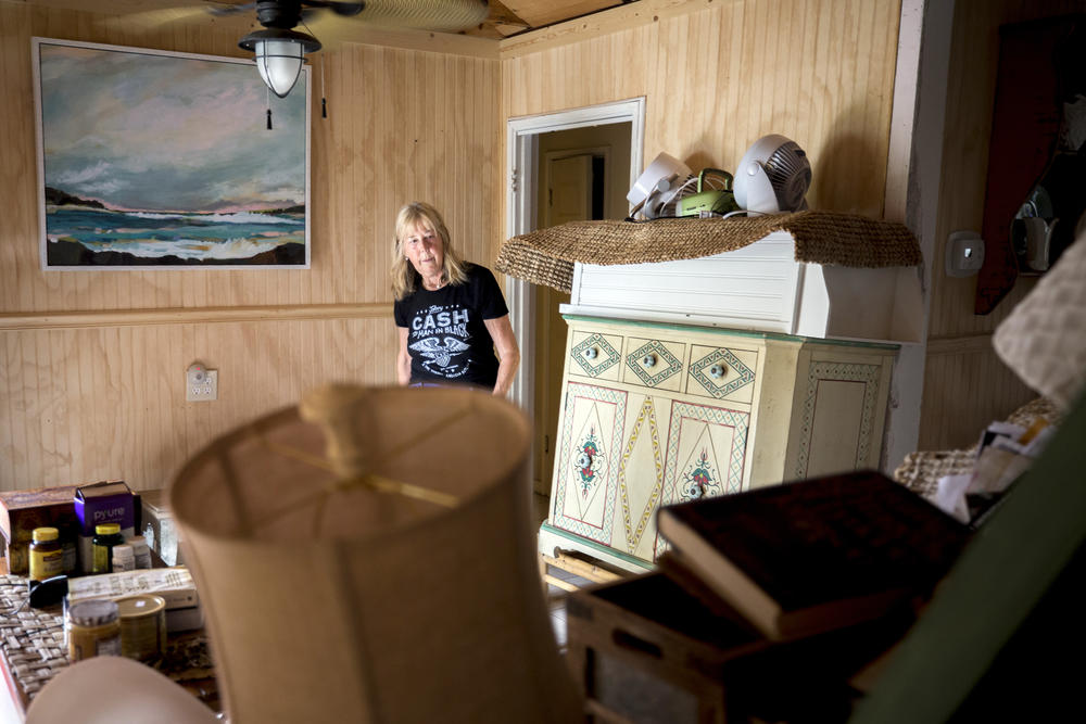Fran Galloway walks past the stacked furniture in her home before she evacuated from Hurricane Dorian.