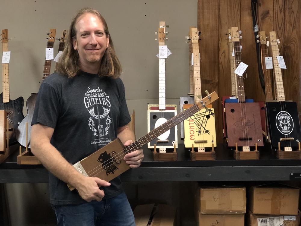 Mike Snowden in his Marietta home-based shop. He crafts and sells cigar box guitars.