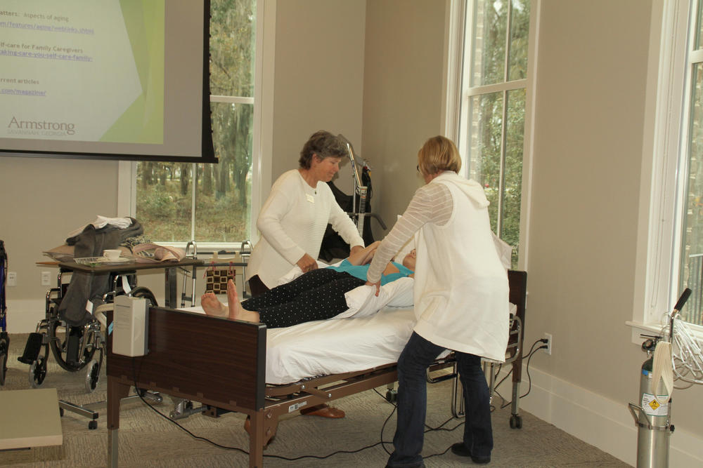 Instructors demonstate how to maneuver a bed ridden patient