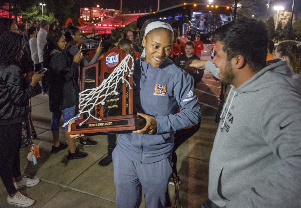 Mercer's KeKe Calloway carries the SoCon Basketball Tournament trophy off the team bus as she and the rest of the Bears arrive back on Mercer's campus Sunday night. Winning the conference title means the Bears advance to the NCAA Tournament.