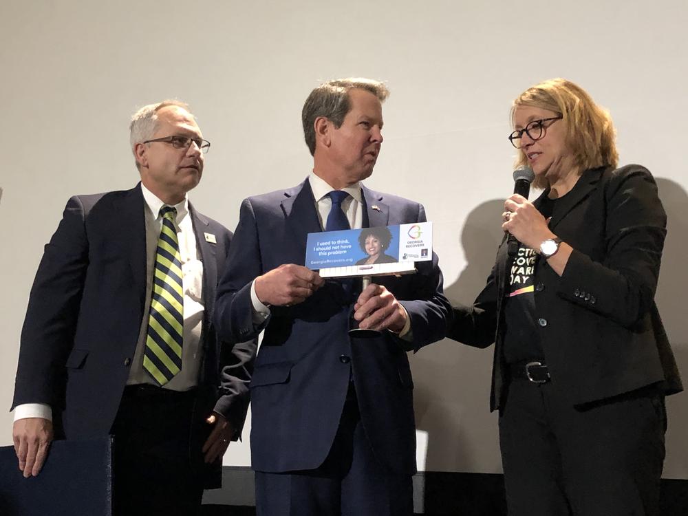 Jeff Breedlove (left) and Neil Campbell on Jan. 28, 2020, present Gov. Brian Kemp with a mini billboard from the Georgia Recovers campaign.