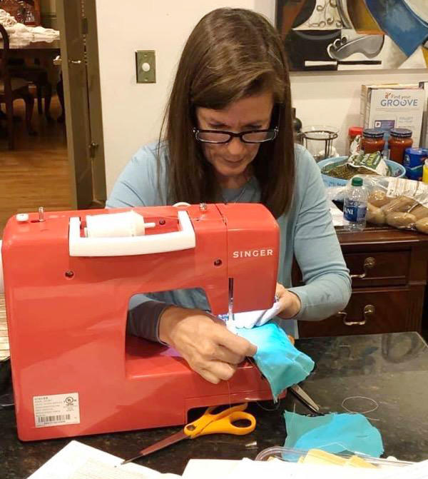 Leslie Owens sews together protective mask covers outof surgical linen in her Albany home. 