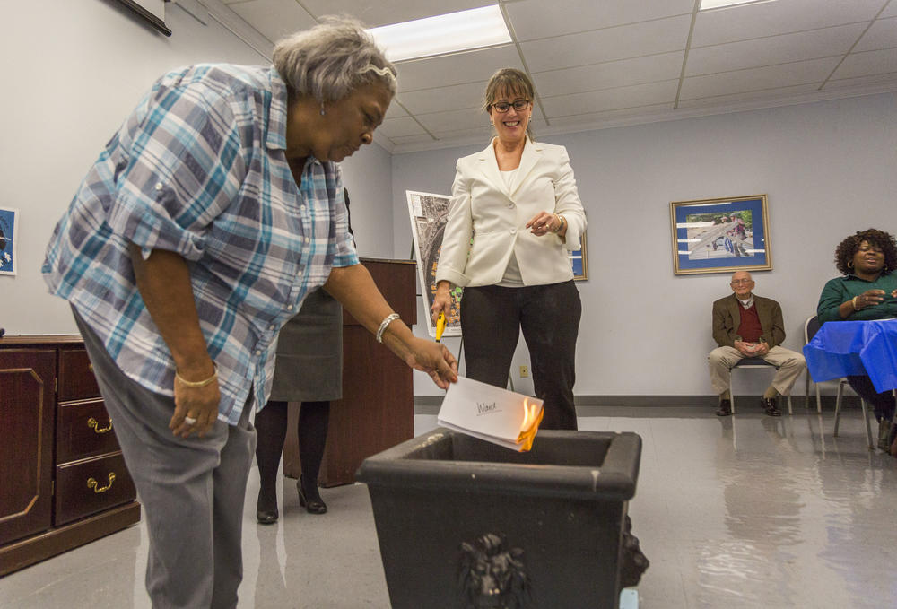 Lillie Ward burns her mortgage in a ceremony at Macon Area Habitat for Humanity recently. 
