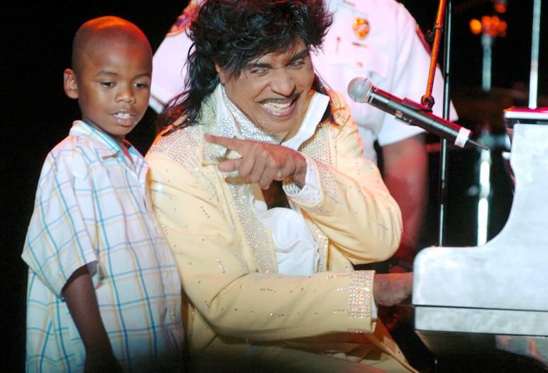 Little Richard entertains a Macon crowd at the Coliseum in 2001 while his nephew looks on.
